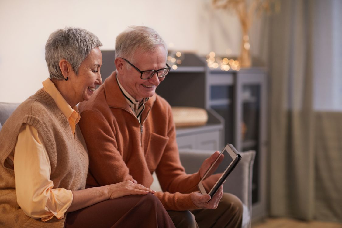 Senior couple using a tablet together to explore their plan
